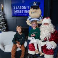 Boy and girl smile with Santa and Louie